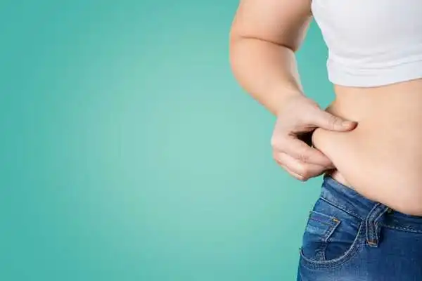 Image of woman pinching her love handles to show weight gain Barnsley